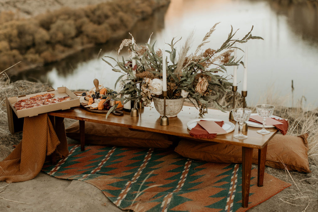 Image of a whimsical newlywed table overlooking a lake organized for a photography workshop.