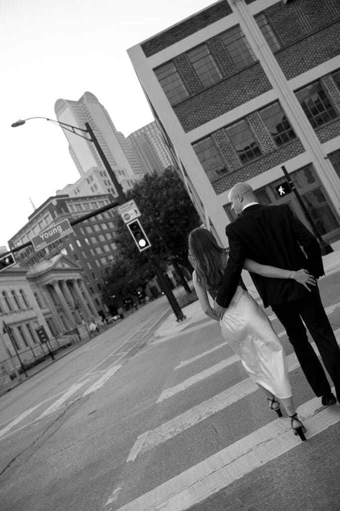 couple walking through downtown dallas with their arms around each other