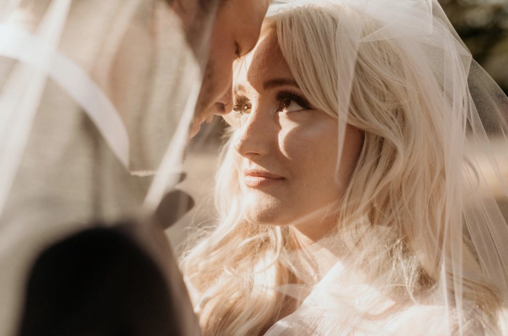 Choosing An Oregon Elopement Photographer: Everything You Need To Know. Bride looks up at groom's face under her veil photographed by Morgan Wirth