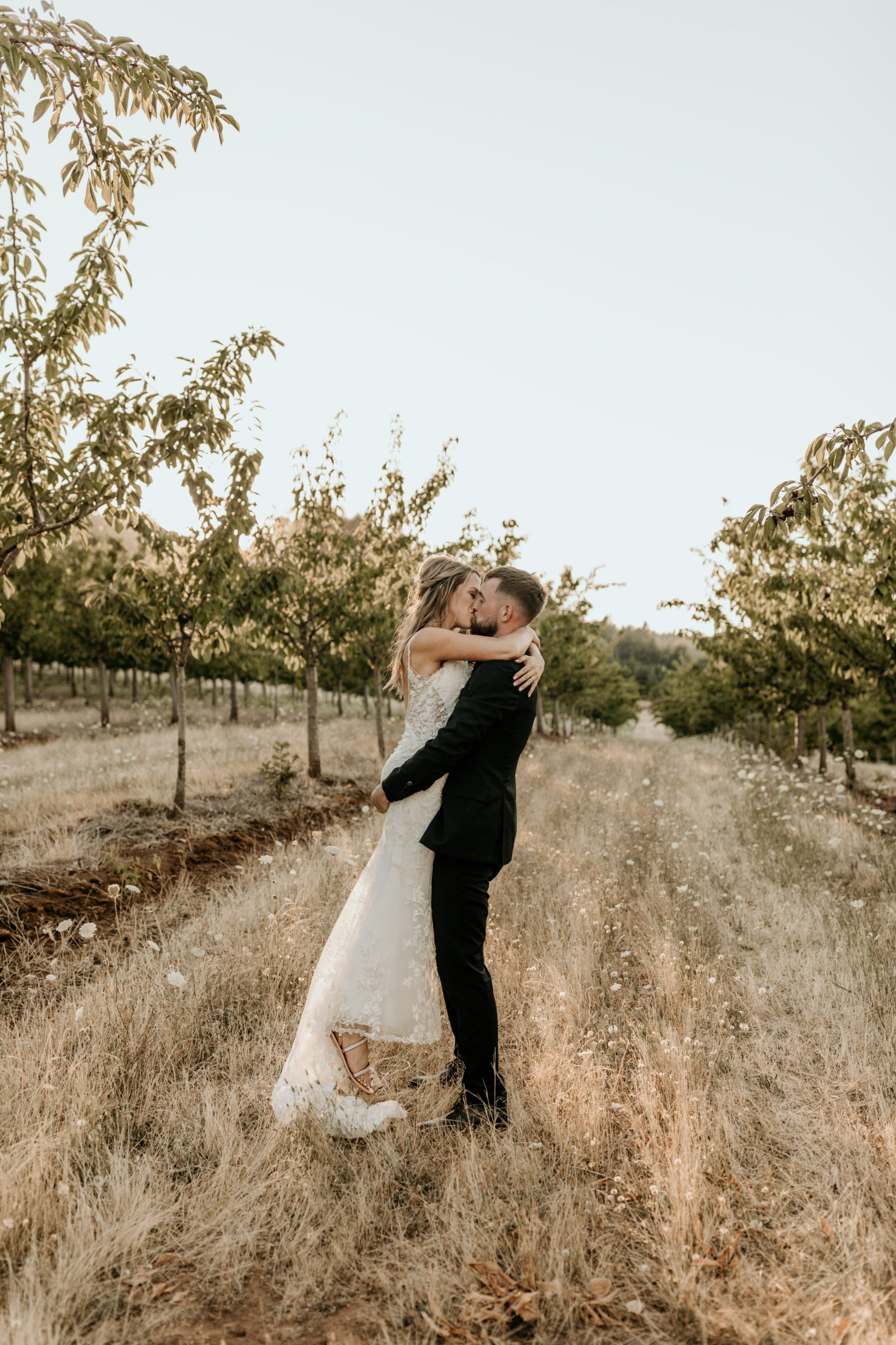 Groom carries bride up as they share a kiss during their Oregon Badlands wilderness elopement, captured by Morgan Wirth Photography