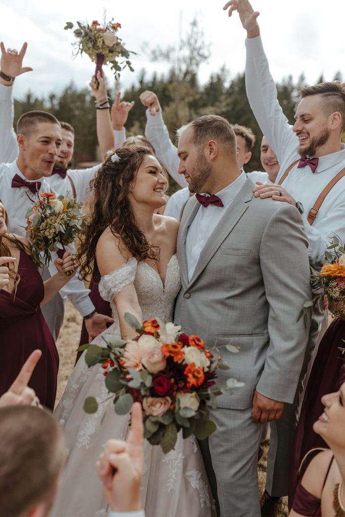 full bridal party cheering around couple