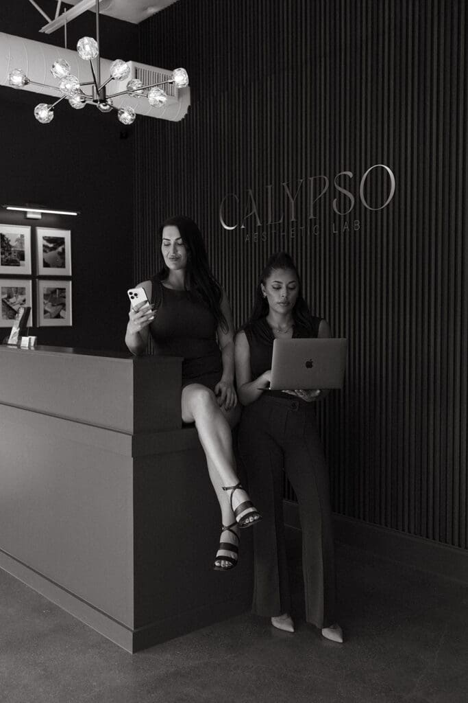 Two med spa team members at front desk during Dallas brand session.