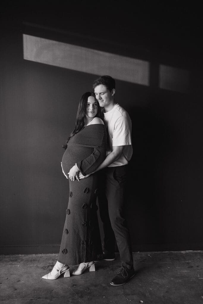 Pregnant woman holding her belly during an editorial maternity session in a Dallas studio.