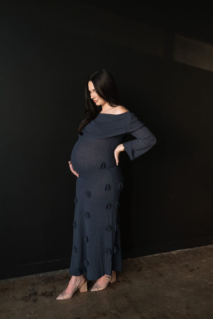 Side profile of expecting mother in elegant navy dress during an editorial Dallas maternity shoot.