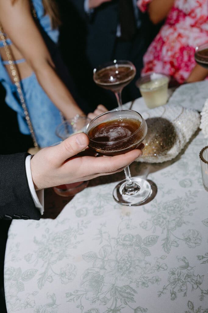 Guests holding espresso martini for a toast, captured in an editorial, documentary-style reception detail at The Mason wedding in Dallas