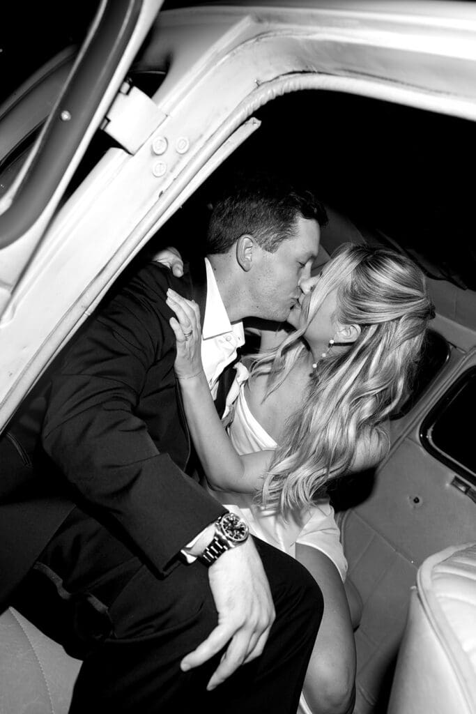 Bride and groom kissing by the getaway car, a cinematic editorial and documentary wedding moment at The Mason in Dallas.