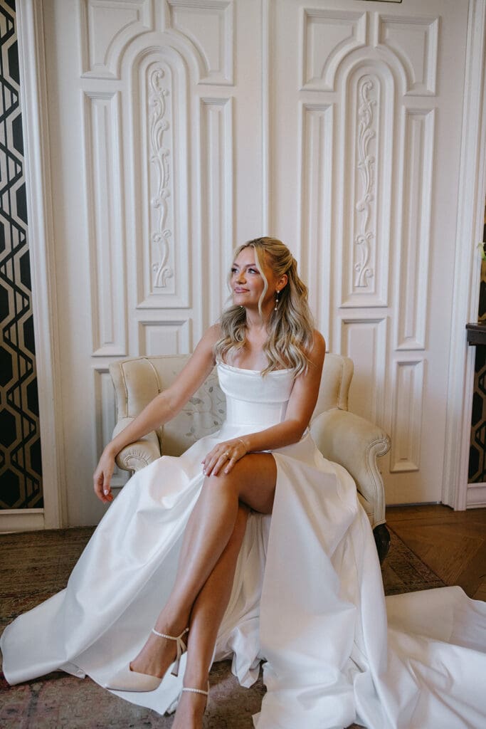 Bride sitting in a vintage chair in her wedding dress at The Mason in Dallas.