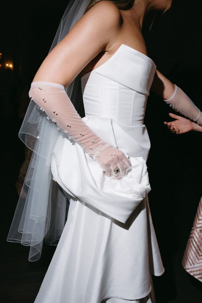 Bride holding her veil and bouquet in elegant gloves at The Mason in Dallas